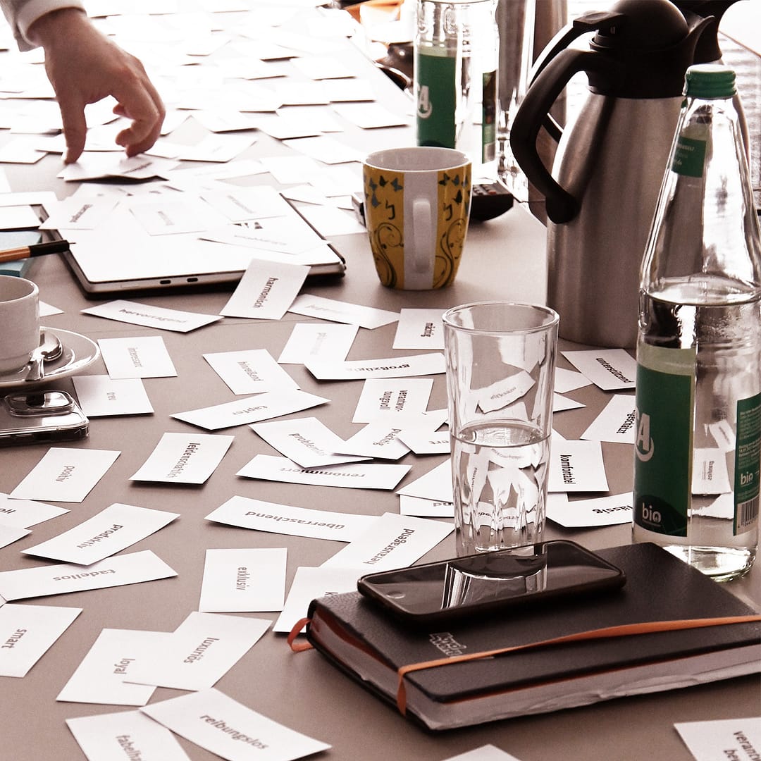 BEING BORN – Our clients: Vielfalt, Markenattribute & Zusammenarbeit Markenworkshop von BEING BORN mit Lloyd Werft. Karten mit Markenwerten liegen auf dem Tisch und zeigen den kollaborativen Prozess, gemeinsam Markenidentität und Branding zu entwickeln.