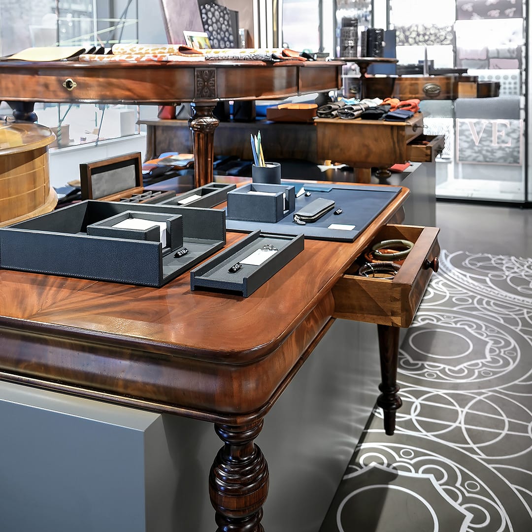 BEING BORN – Bethge Shop Hamburg: Antiker Tisch im modernen Retail Design Bethge Shop Hamburg – antiker Tisch im Retail Design von BEING BORN, der klassische Eleganz mit moderner Präsentation und kontrastreichem Materialeinsatz verbindet.