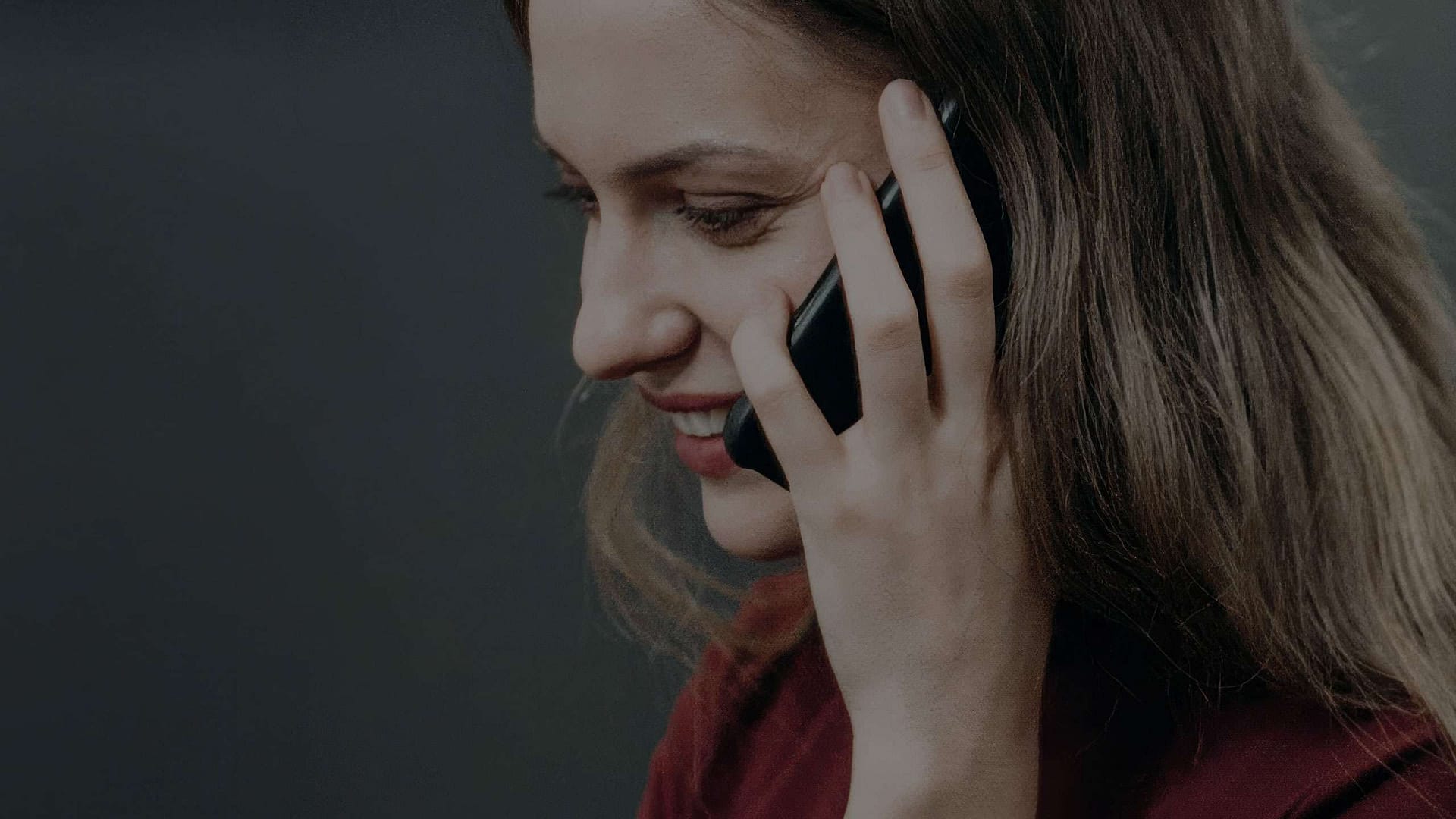 Lachende Frau am Telefon – contact-Seite von BEING BORN, Agentur für Innenarchitektur, Retail Design und Corporate Design in Hamburg.